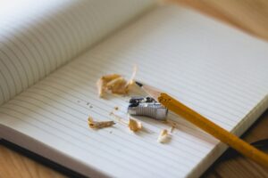 Sharpened pencil and notebook—writing a research paper abstract
